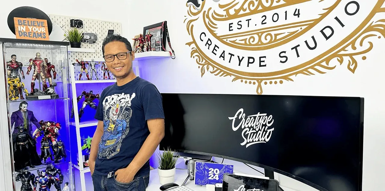 Rian Rahardi in the Creatype Studio office, next to a wide monitor